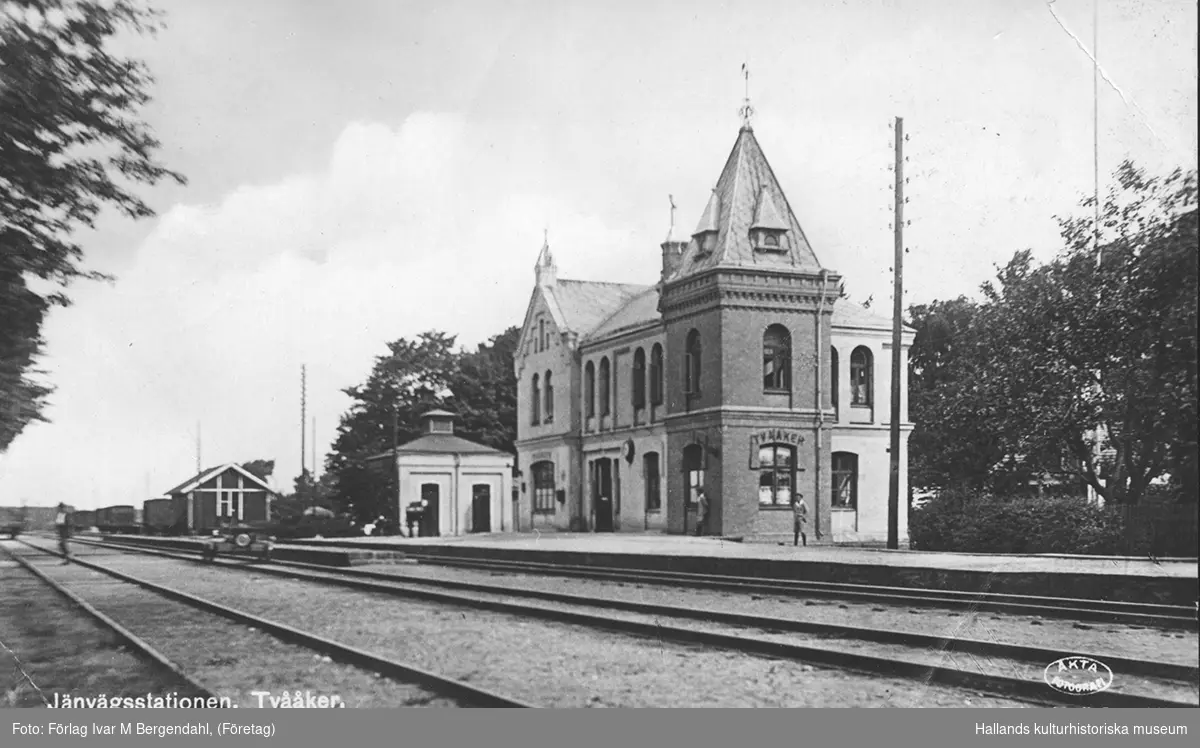 Vykort, "Järnvägsstationen, Tvååker. Äkta fotografi." Kortet postades 1927 och visar stationen från spårsidan. Stationshusen längs Mellersta Hallands järnväg ritades av Adrian C Peterson och ett likadant uppfördes på Slöinge station. Det kraftiga tornet på hörnet har fortfarande sin tegelfasad blottlagd, men fasaden i övrigt blivit putsad eller slammad. Tvååkers järnvägsstation elektrifierades på 1940-talet.