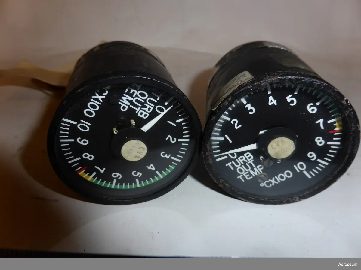 Två stycken turbintemperaturindikatorer. Motorinstrument. Gjorda i svart metall.

På den ena av dem finns det en hängande ettikett där det står: "LIR 52" och på andra sidan står det "Important remove this shunt before connecting or fitting socket to instrument". Det finns också en fastklistrad ettiket där det står: "T7409 1 HKP [går inte att tyda]". På botten av instrumentet står det: "USE 8 OHM C.A. LEADS", "SERIAL NO 1958", "PART NO. 22-304-04", "TEMP. IND. WESTON INSTRUMENT INC. WICHITA, KAN.", "F.A.A. TSO-C43 TYPE II WT. 1 LB."

På det andra föremålet står det på botten: "USE 8 OHM C.A. LEADS", "SERIAL NO 1796", "PART NO. 22-304-04", "TEMP. IND. WESTON INSTRUMENT INC. WICHITA, KAN.", "F.A.A. TSO-C43 TYPE II WT. 1 LB.". Det finns även en påklistrad ettikett där det står: "T74 [går inte att tyda]"