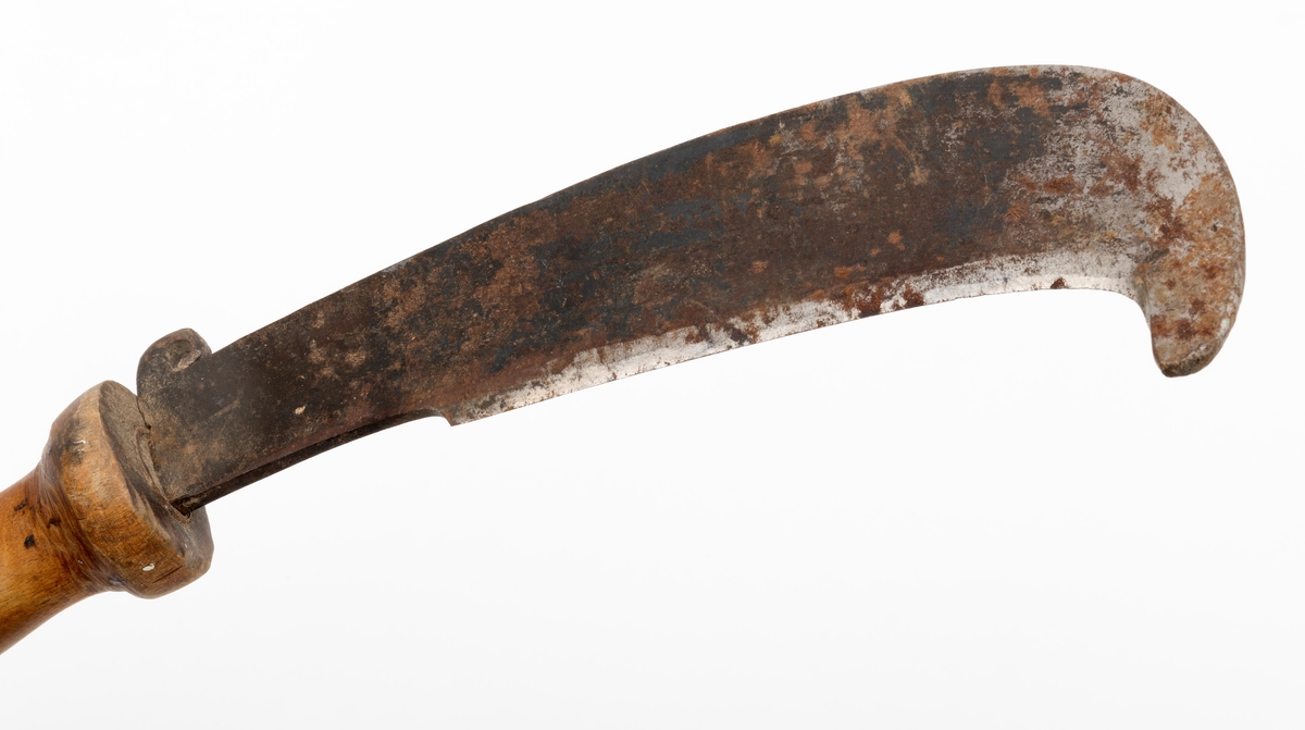 Kniv, lauvkniv, bestående av et håndtak og kraftig blad med egg. Bladet har en innoverbøyd hake ved spissen på eggsida. Bladet er merket med produsentens stempel. Det er innslag av noe rust på bladet. Tangen på knivbladet går tvers gjennom skaftet. Skaftet er solid utformet med en fortykning mot bladet som beskytter brukerens hånd. Lauvkniver av denne typen ble brukt til fôrsanking.