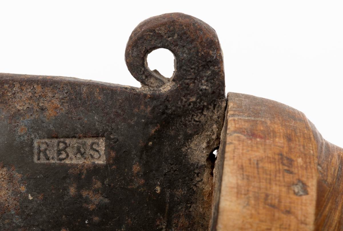 Kniv, lauvkniv, bestående av et håndtak og kraftig blad med egg. Bladet har en innoverbøyd hake ved spissen på eggsida. Bladet er merket med produsentens stempel. Det er innslag av noe rust på bladet. Tangen på knivbladet går tvers gjennom skaftet. Skaftet er solid utformet med en fortykning mot bladet som beskytter brukerens hånd. Lauvkniver av denne typen ble brukt til fôrsanking.