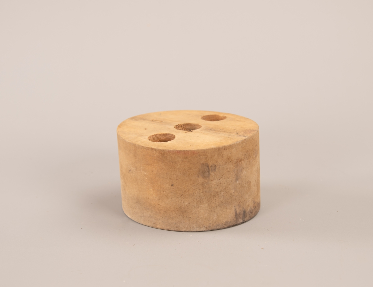 Oval hatteform med tre like store hull boret inn på oversiden. Hullene er 4,5 cm dype.