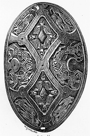 Oval bronsespenne med støpte ornamenter fra vikingtid. Variant av type Rygh 647. Funnet i en haug på gården Tråset i Fåberg i 1887.