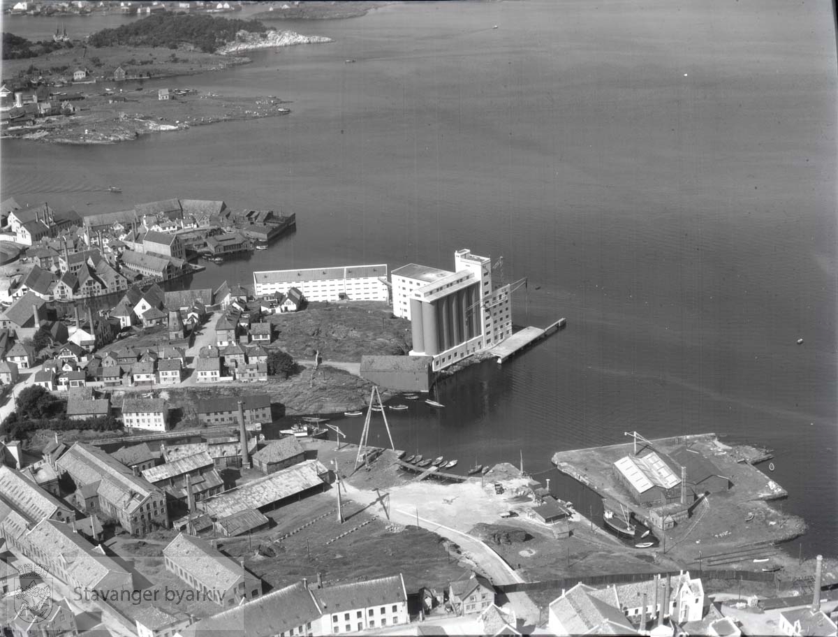 Stavanger Støberi & Dok (Hammerverket) i forgrunnen. Dokk nr. 2 til høyre..Midt i bildet Vindmøllen ved Vindmøllebakken. Videre Nordkronen Mølle (nå: Norgesmøllene). Dokkgata, Dokksmauet, Støperigata, Badehusgata, Ramslandsbergjet, Ramslandssmauet, Verven, Pedersgata.