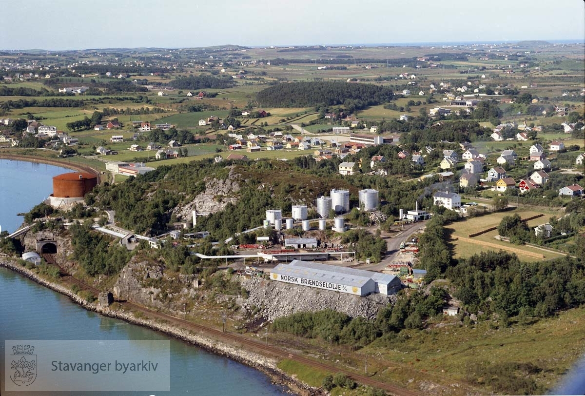 Lura..Bebyggelse ved Gamleveien ( Sandnes ), Nadabergveien, Lønneveien, Lurastø, Bjørkeveien, Eikeveien, Apalveien, Granveien, Furuveien, Askeveien, M. Hamravei, Ø. Hamravei, Veslefrikkveien, Tyrihansveien, Trollveien, Lerkeveien..I forgrunnen tankanlegget (nå: Statoil), Jærbanen..I bakgrunnen Lura skole..Bildet tatt mot sør-vest