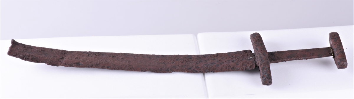Sverd av type Rygh 489 der nederste del av klingen er avbrukket. Fra vikingtid. Funnet i veikanten mellom Dyren og Rognstad i 1907.