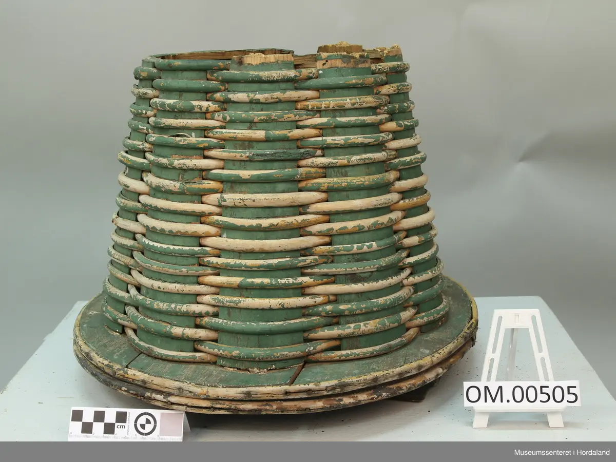 Grønn fletta korg eller kipe til å ha fisk i.