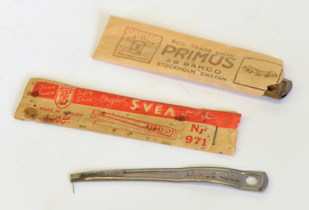 
A: Papplåda sammanhållen med papperstape med texten AB Bacho Stockholm Sweden och Primus Regd Trademark. Stor etikett med produktens namn och en bild på ett brinnande Primuskök mot solnedgång. Produktinformation på många olika språk. I etikettens övre högra hörn sitter en röd lapp som talar om att förpackningen innehåller Primus säkerhetskanna.  

B: Själva köket. Höjd 220 mm, diam 210 mm. Två ringar över en brännare. Behållare för rödsprit. Namnet Primus  återfinns över hela köket. Etikett i snöre finns också.

C: Kanna för rödsprit. Primus säkerhetskanna.

D: Pappersförpackning, 80 mm lång. Text: Svea Swedish Safety stove Original Svea Nr 971. Innehåller tre stycken rensnålar för rensning av brännaren.

E: Pappersförpackning 115 mm lång. Text: Reg Trademark Primus AB Bacho Stockholm Sweden No 4605. Innehåller tre stycken rensnålar av märket Primus och en av märket Svea.

Från Arne Ekströms Handelsmuseum.

Modell: Primus No 5