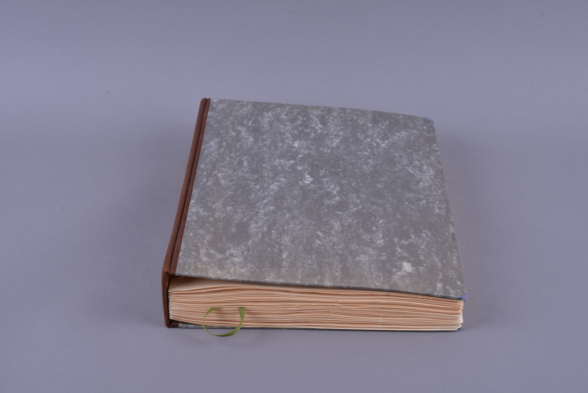 Innbundet bok med punktskrift. Tosidig trykk. Gråsvart omslag av kartong. Forsats av oransje papir. Sidene er av oransje papir. Tekstilhalvbind; ryggen og hjørnene er forsterket med rød tekstil. Sidene er heftet sammen ved hjelp av to meltallstenger som er festet til permene.