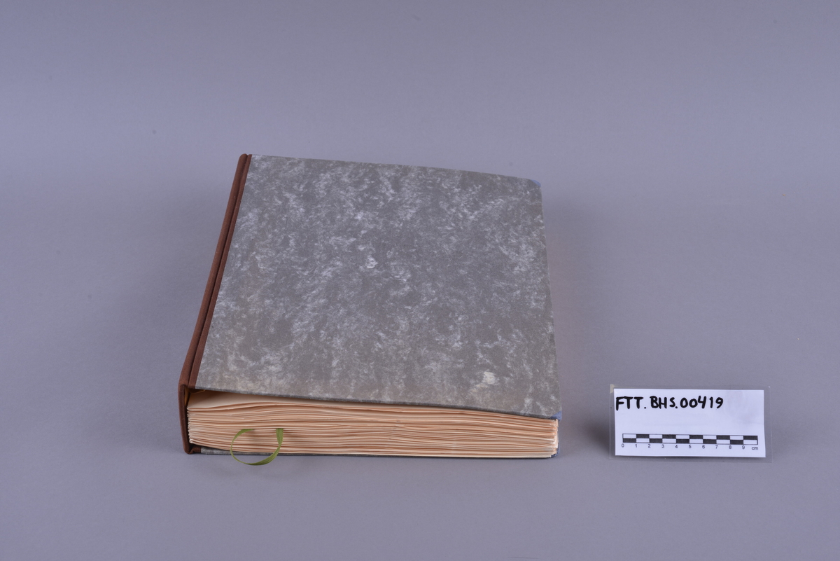 Innbundet bok med punktskrift. Tosidig trykk. Gråsvart omslag av kartong. Forsats av oransje papir. Sidene er av oransje papir. Tekstilhalvbind; ryggen og hjørnene er forsterket med rød tekstil. Sidene er heftet sammen ved hjelp av to meltallstenger som er festet til permene.