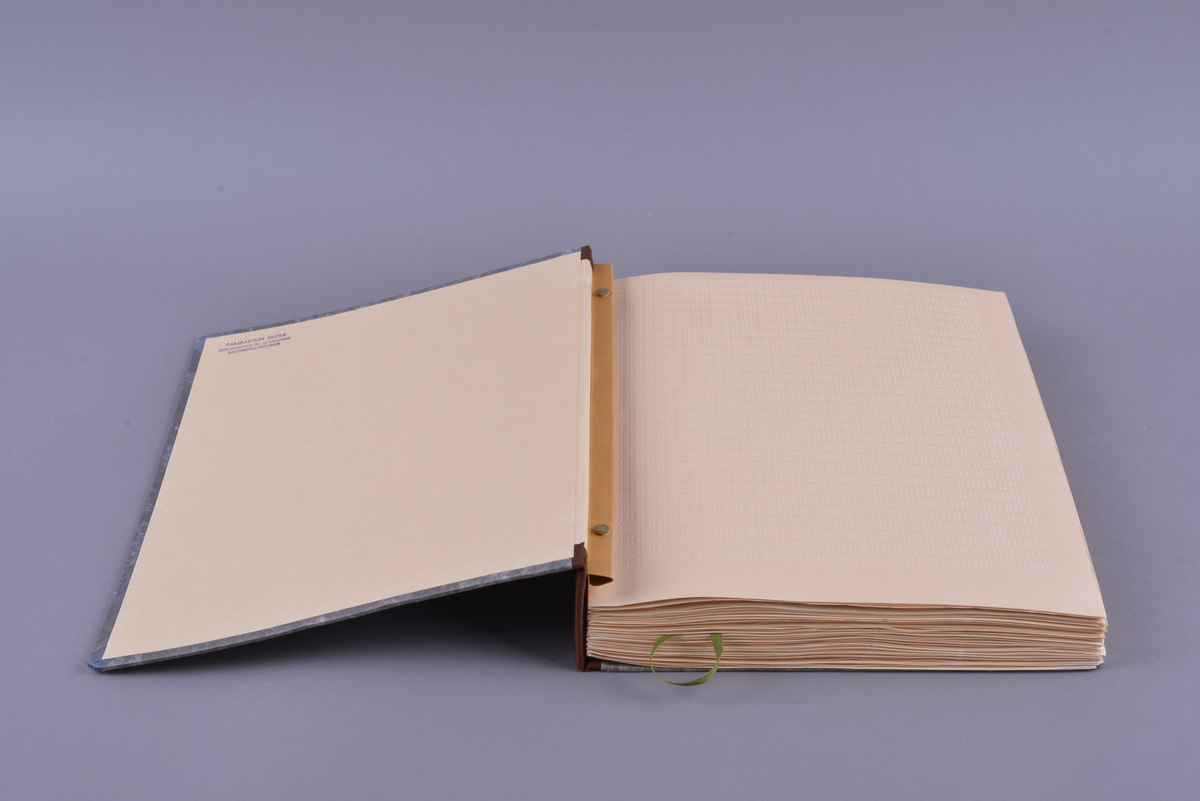 Innbundet bok med punktskrift. Tosidig trykk. Gråsvart omslag av kartong. Forsats av oransje papir. Sidene er av oransje papir. Tekstilhalvbind; ryggen og hjørnene er forsterket med rød tekstil. Sidene er heftet sammen ved hjelp av to meltallstenger som er festet til permene.