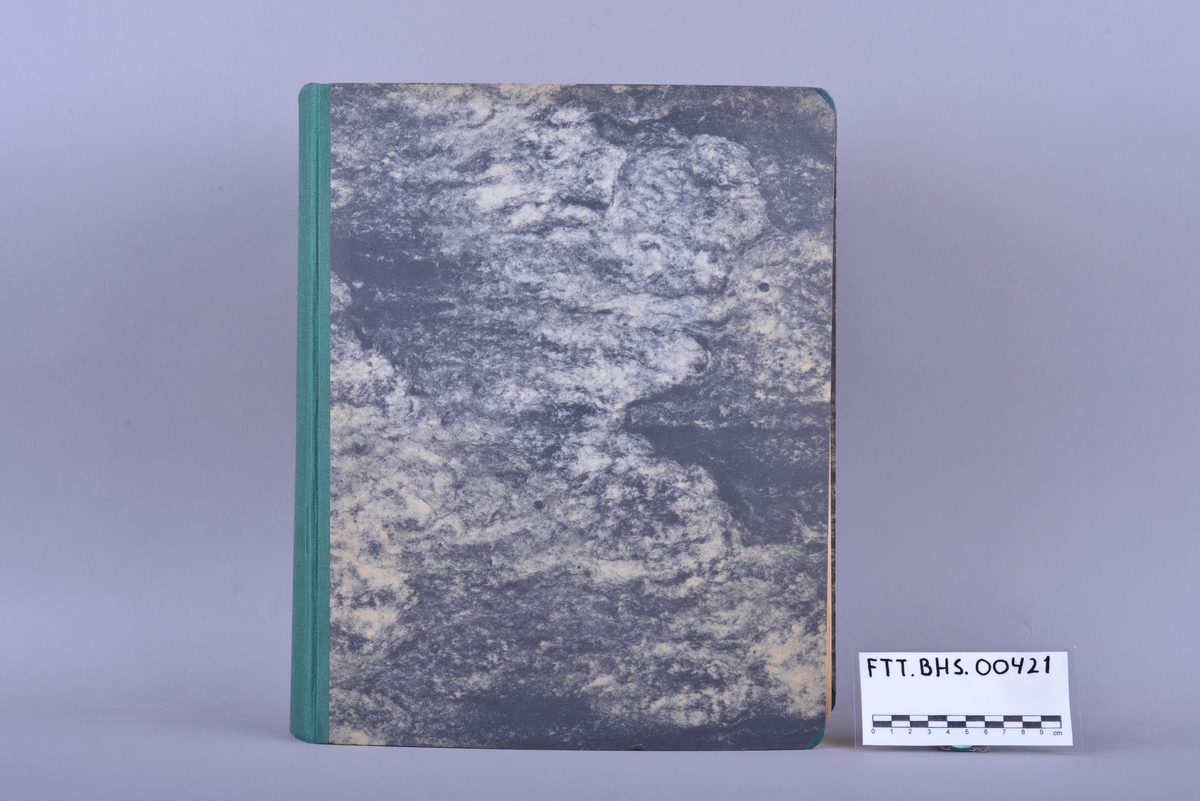 Innbundet bok med punktskrift. Tosidig trykk. Gråsvart omslag av kartong. Forsats av gult papir. Sidene er av gult papir. Tekstilhalvbind; ryggen og hjørnene er forsterket med grønn tekstil.