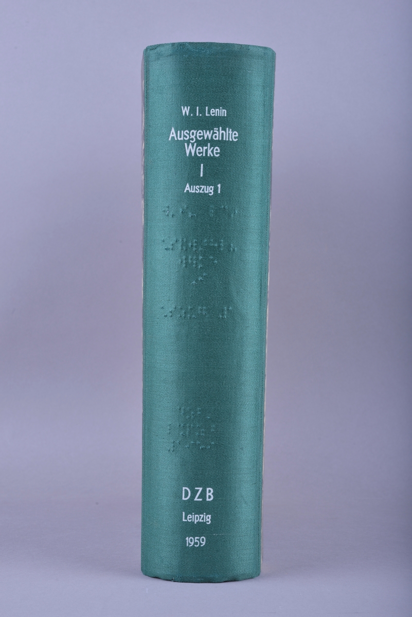 Innbundet bok med punktskrift. Tosidig trykk. Gråsvart omslag av kartong. Forsats av gult papir. Sidene er av gult papir. Tekstilhalvbind; ryggen og hjørnene er forsterket med grønn tekstil.