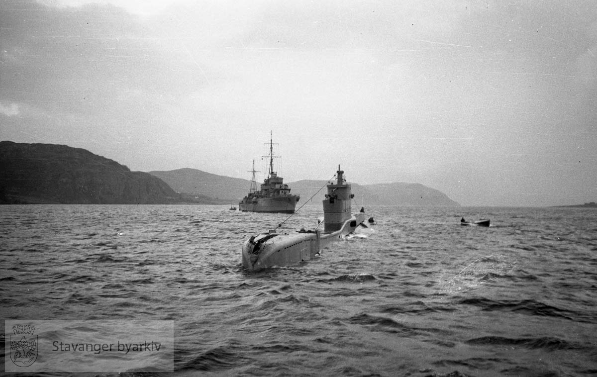 I dårlig vær på norskekysten ble dybderorene akter på den nye britiske u-båten HMS "Triad" skadet. Destroyerne HMS "Inglefield" - D02 - og HMS "Maori" - F24 - gikk til assistanse og eskorterte "Triad" inn i Mastrafjorden 30.11.1939.. .Offiserer på den norske torpedobåten "Stegg" bordet "Inglefield" for konferanse. "Triad" ble først forsøkt reparert i Mastrafjorden, men da dette ikke lyktes måtte u-båten taues til Rosenberg mek. verksted for reparasjon. De to destroyerne forlot da norsk farvann.. .Alle de fire ovenfor nenvte skipene i foto-serien gikk tapt i løpet av krigen...Heist kommando:."Stegg" 1921-1940."Triad" 1939 -1940."Inglefield" 1937 - 1944."Maori" 1938 - 1942..(Opplysninger gitt av Einar Haualand, 30.10.2022)...