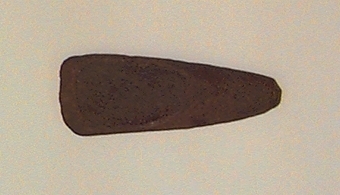 Tvärsnittet ovalt mot eggen, runt mot nacken. Vittrad.