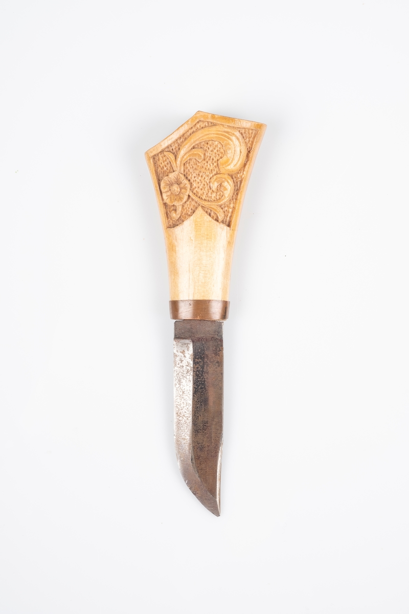 Tollekniv med skaft i tre og knivblad i jern. Det er utskåret akantusmønster på skaftet. Bolsteret er i kobber.