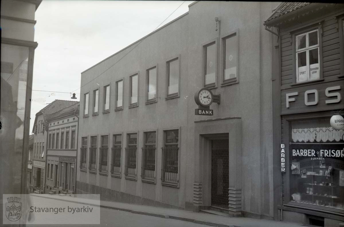 Til høyre lokalene til barber J. Jensen. Til venstre etter bankbygningen: T.O. Engelsgjerd og Elektrisk Bureau...Hjørnet av Kirkegata 32 i venstre bildekant.