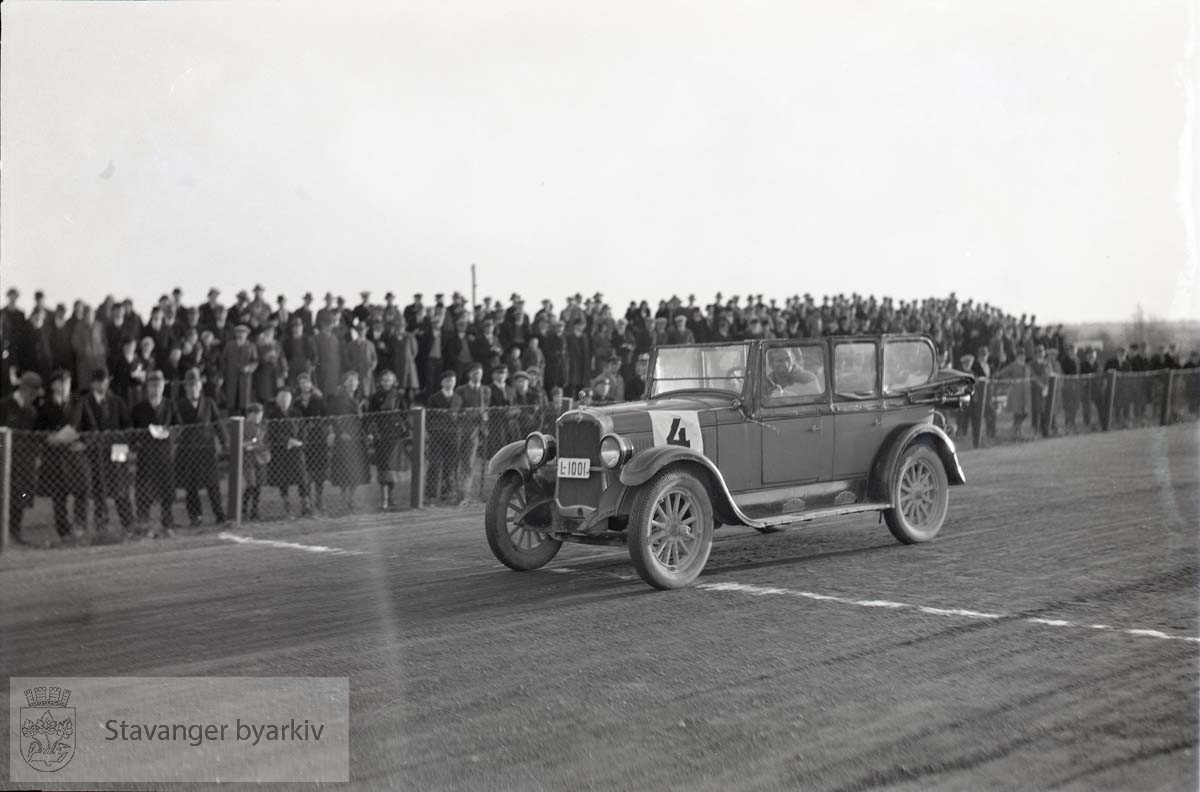 Bil på banen. Rallybil. .Tilskuere langs banen.