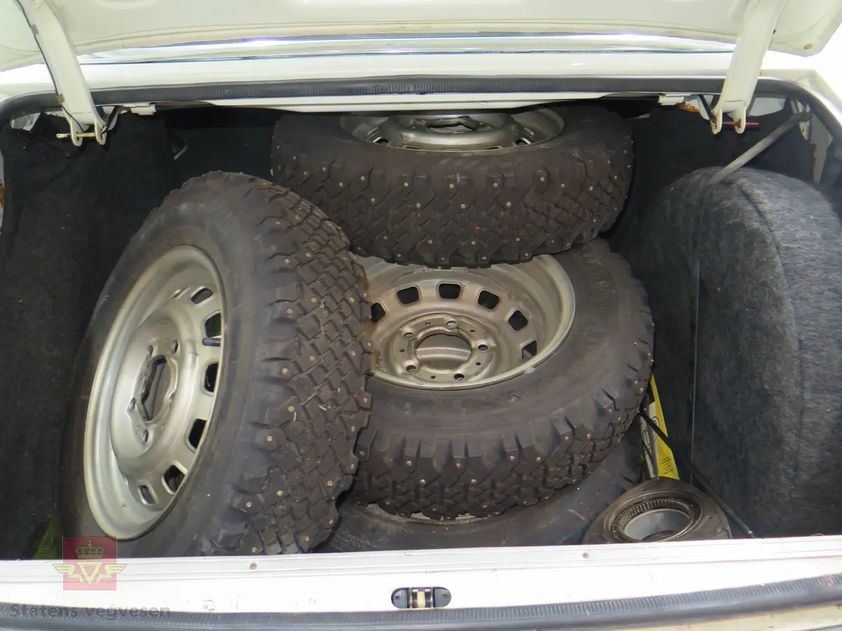 NSU RO 80. 4-dørs hvit bil med brunt interiør. Bilen har en bensindrevet dobbel NSU/Wankel rotasjonsstempelmotor, med sylindervolum på 994 kubikkcentimeter (cm3), og effekt på 115 DIN HK. Dekkdimensjon foran og bak skal standard være 175 HR 14. Framhjulstrekk. Girkasse med 3 gir framover pluss revers. Kilometerstand er 75385.