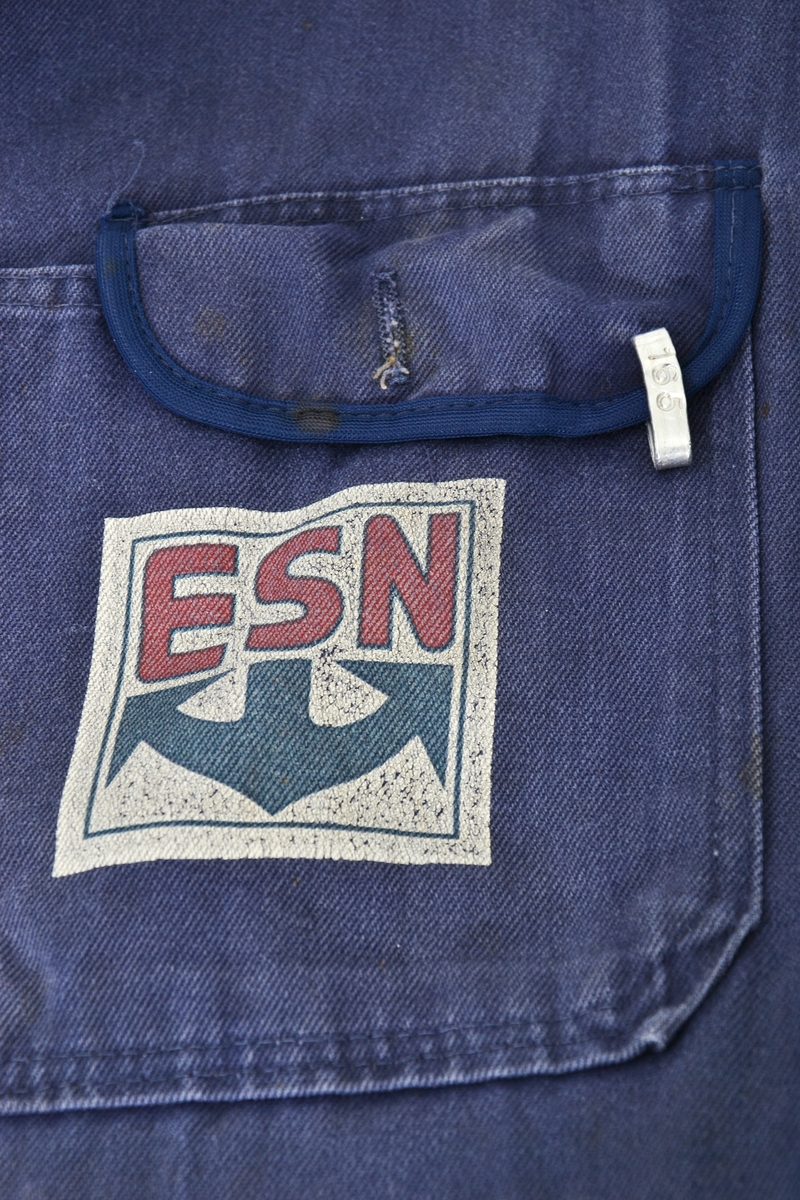 Blå bomullskjeledress i størrelse 56 med logo på venstre brystlomme. Lukking med metallknapper. To brystlommer og to stikklommer i front og to baklommer og strikk i ryggen.  
Logoen er utformet som et kvadrat med hvit bunnfarge og bokstavene ESN i rødt øverst og et stilisert blått anker under.
Kjeledressen har et metallmerke i venstre brystlomme - nr. 165; brukers arbeidsnummer - som var viktig i forbindelse med vask av arbeidstøyet.