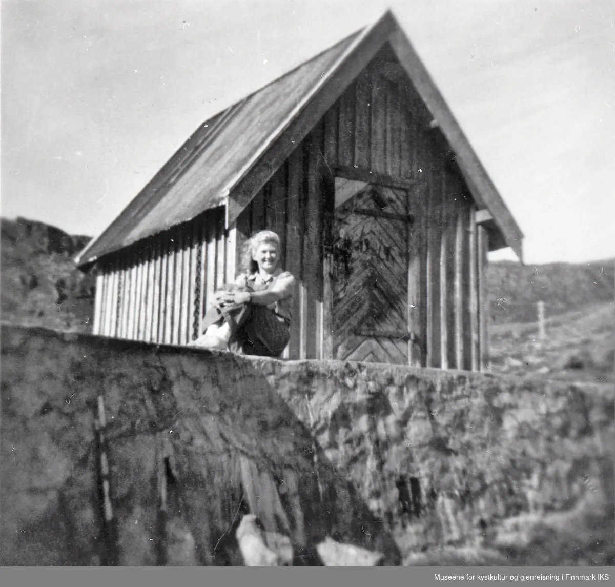 Nordvågen. Irene Helgesen (g. Eriksen) foran vannhuset ved Prestevannet. 1950-tallet.