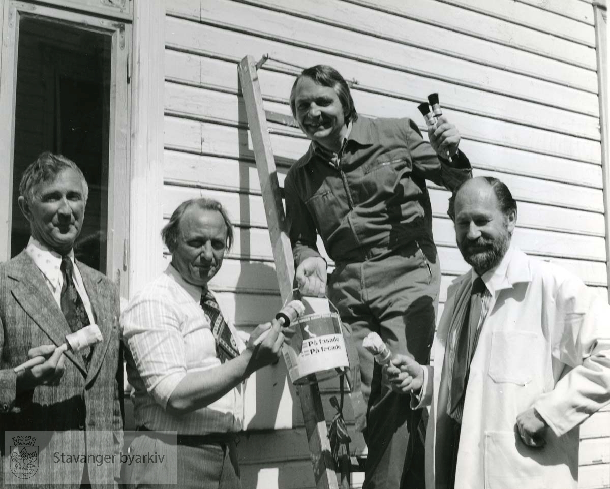 Ordfører Arne Rettedal maler hus i Øvre Strandgate (?) Her sammen med tidligere Riksantikvar Stefan Tchudi Madsen til høyre og leder av Fargerådet Yngar Holm