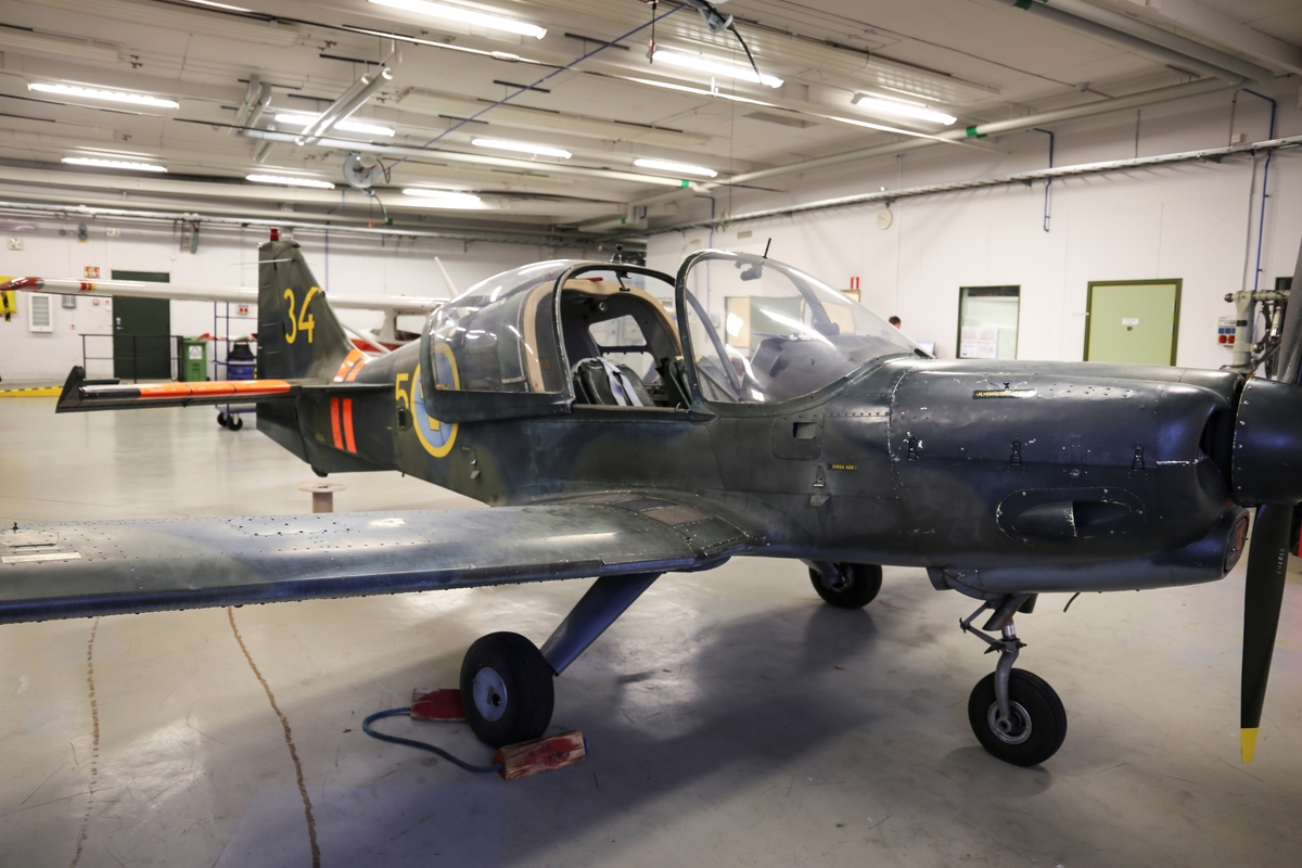 Skolflygplan SK 61A
Beagle B 125 Bulldog

Flygplanet är målat grönt med ljusblå undersida.
Märkning: Under nosspetsen kodsiffra 34; på bakkroppen kronmärke och flottiljnummer 5; på fenan kodsiffra 34.