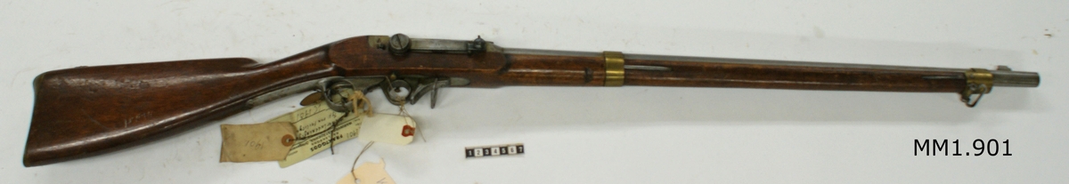 Kammarladdningsgevär m/1851, typ von Feilitzen (Carl Gustafs stad), utan bajonett. Märkt: "I.F. 10". Kolven av trä, pipa och mekanism av stål. Beslagen av metall. Pipan räfflad med 6 räfflor.