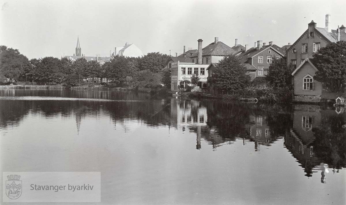 Kongsgata 47 og 49 ble bygget i 1867 etter tegninger av Conrad Fredrik von der Lippe. Nr. 47 var hans egen bolig. Bygningen lengst til høyre, Kongsgata 49, var frem til 1900 lokaler for Frøknerne Rings Pigeskole. Skolegården bak plankegjerdet, Kongsgata 45, opprinnelig oppført som bakeri i 1905 ble i 1910 til Gustav Nestings kjemiske renseri, slik skiltingen på bygget viser her...Breiavatnet i forgrunnen.Petrikirken helt i bakgrunnen.