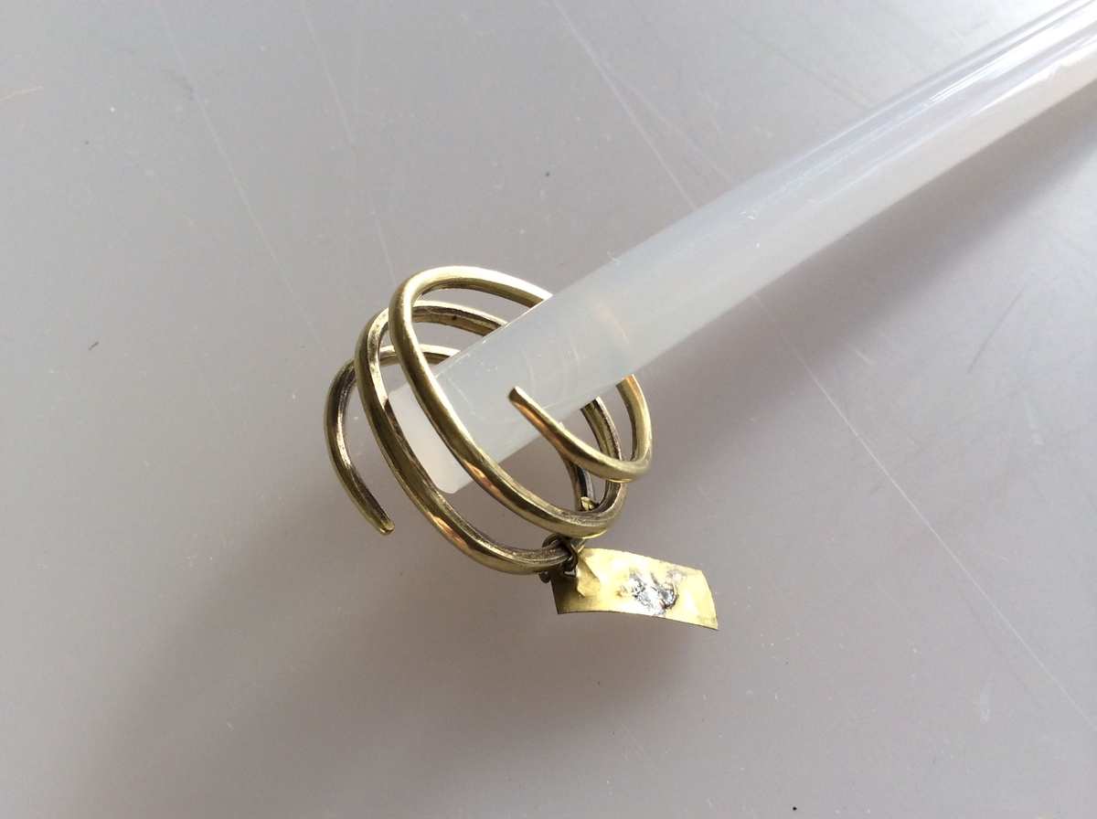 Spiralformet gullring ganske som type Rygh 303, fra yngre romersk jernalder. Funnet i en kvinnegrav på Vestby under Evang i 1885.