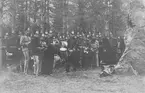 Musikkåren iklädd modell ä, i skogsterräng, 1920-1930-talet