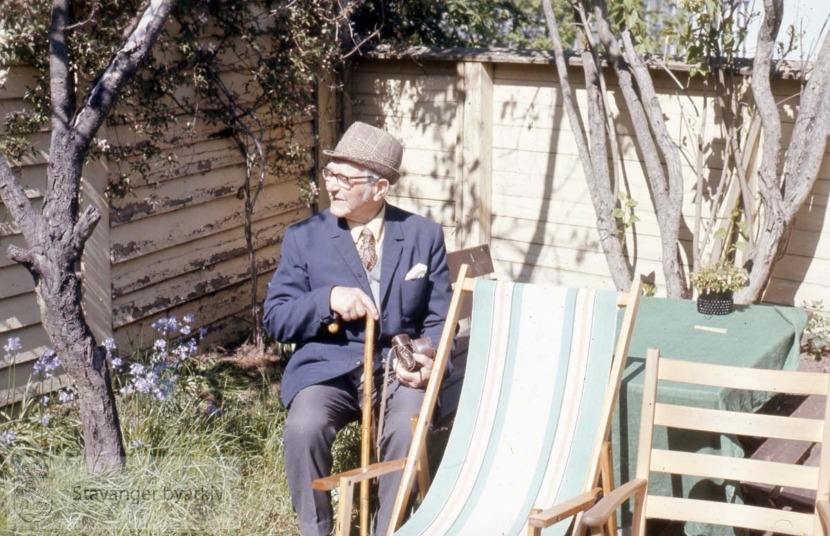 Gunnar Wareberg sittende i hagen sin