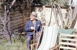 Gunnar Wareberg sittende i hagen sin