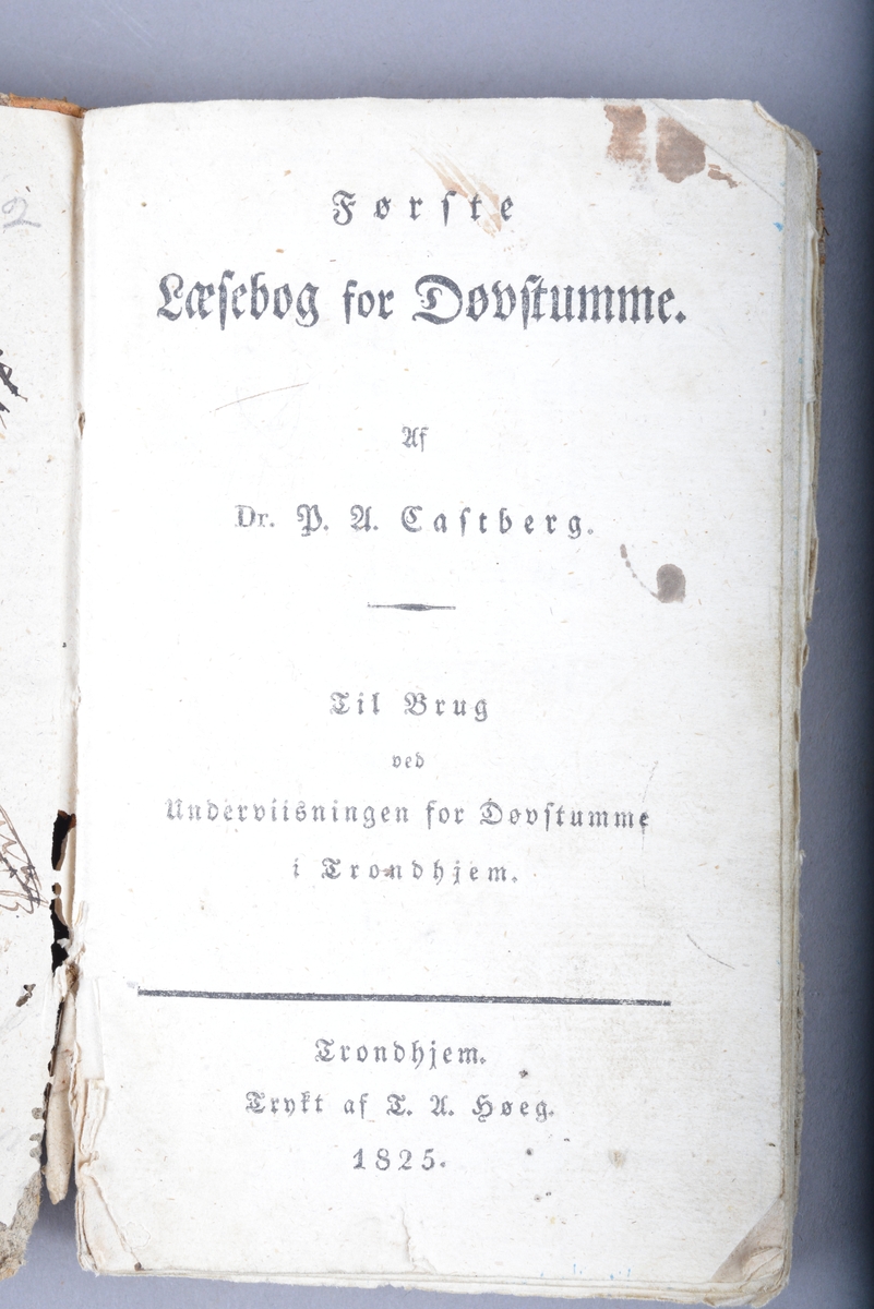 Innbudet bok. Boken er et halvbind med skinn på bokryggen. Marmorert omslag. Håndskrevet tekst på for- og ettersats. Det er også utydelige ord og bokstaver skrevet med blekk og blyant. To tegninger på forsatsen. Disse tegningene er trolig tegnet av barn og viser en ung jente med kjole og en gammel dame med en stokk.
