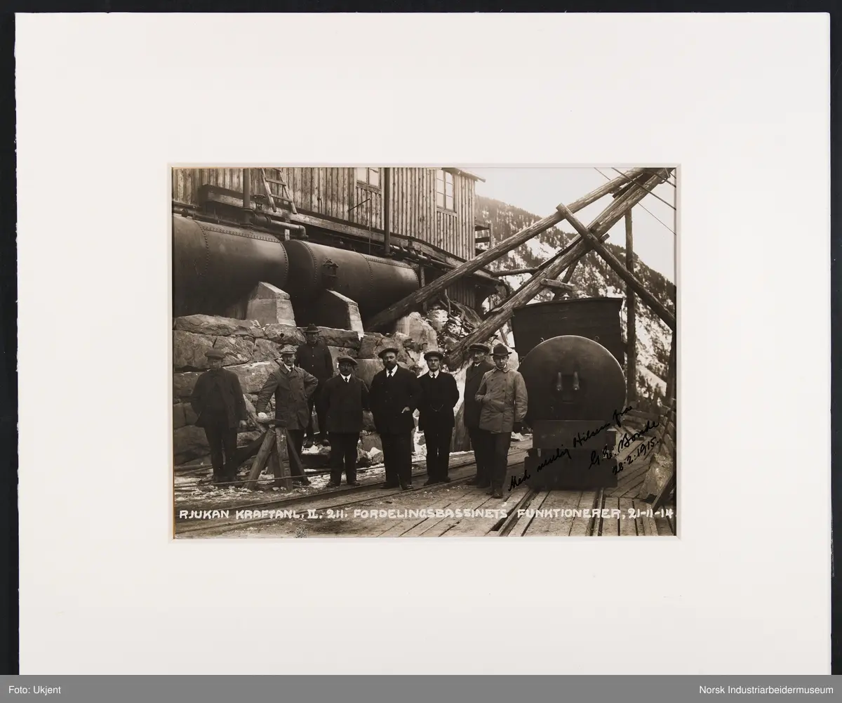 Innrammet foto. Funksjonærer på Norsk Hydro stående foran fordelingsbassenget. Rjukan Kraftanlegg II, Såheim.