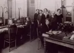 Interiör, troligen från katalogredaktionen, 1920-talet, vid bordet i förgrunden Beda Cederberg.