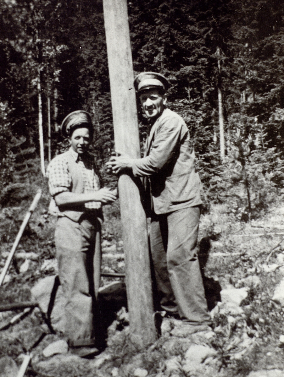 Gustav Svedin och August Lindin sätter en stolpe på linjen Valsjön-Sörnaggen. Året var 1948.