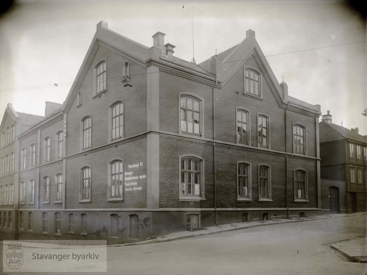 Waisenhusgaten 50 fra sørvest. Stiftelsesgata til høyre. Hjørnehuset, Stavanger tekniske Aftenskole, ble bygd i 1880. Her holdt også Storms skole i sin tid til. Bygningen til venstre er utvidelsen i 1913.