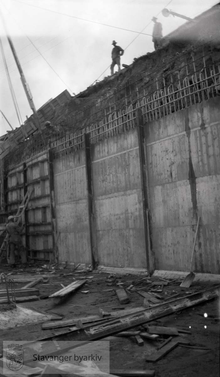 Støping av bassengveggen...Vann fra Store Stokkavatn ble pumpet opp til bassenget på Tjensvollhøyden 89 m o.h.Stokkavatnanlegget startet opp i 1930 og fra da stilnet pumpene i Egenes brannstasjon. Stokkavatnet var byens vannreservoar fram til 1959.