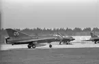 Tre flygplan J 35 Draken på landningsbana på sovjetisk flygbas. Flygplan märkt nummer 05 i förgrunden. Vid Kungliga Upplands flygflottiljs besök vid sovjetisk MiG-21-bas den 16 mars 1972.