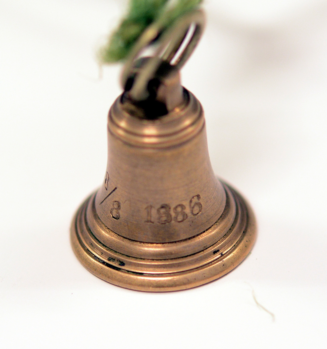 Signet av bronse, med initialene H.I. i dekorativ inngravering og ring rundt, støpt av Skiens gamle kirkeklokker, i klokkeform med feste på toppen og ring i. Medfølgende notat fra giveren til museet.