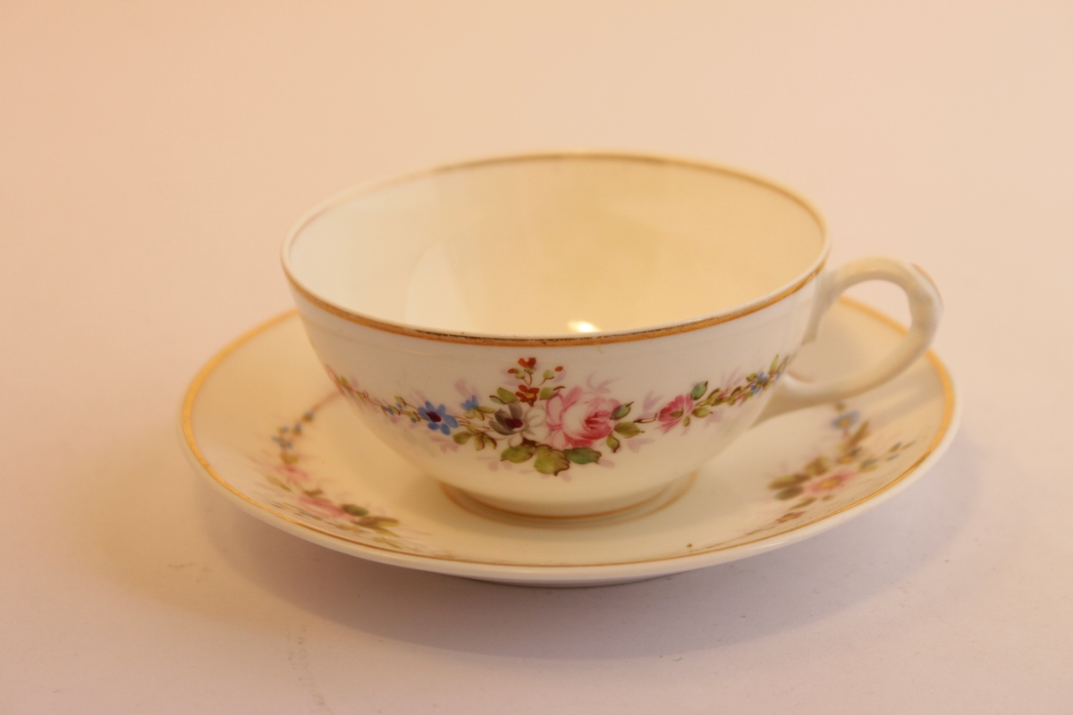 Handmålade mycket tunna porslinskoppar för kaffe. Kopp och fat är båda vita med guldkant. De är dekorerade med ett blommönster som är målat för hand.  Bland annat en ros samt en girland som sträcker sig runt både kopp och fat. Motivet med blommorna upprepas tre gånger runt både kopp och fat. 
Koppar och fat är handmålade av en släkting till givaren under senare delen av 1800-talet.
