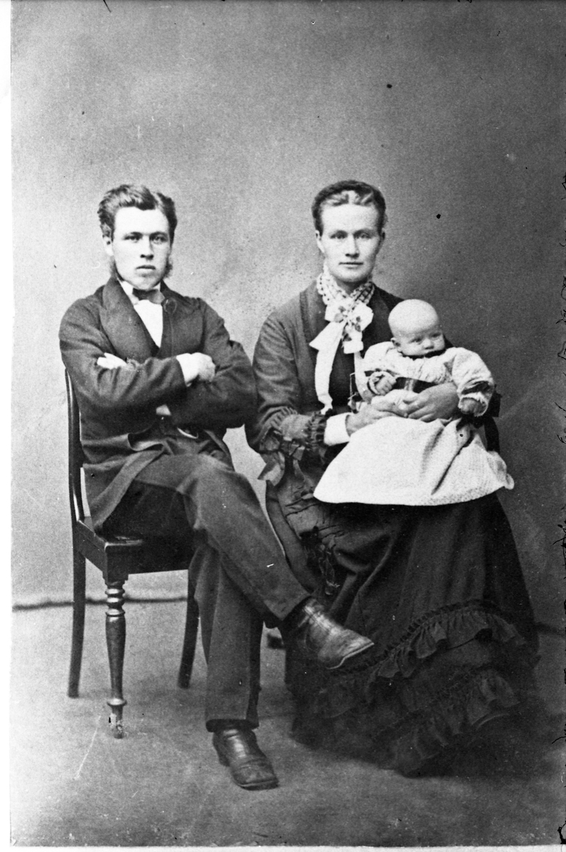 Avfotografert portrett av et ektepar og et lite barn. Hverken personer eller sted (atelier) er identifisert.