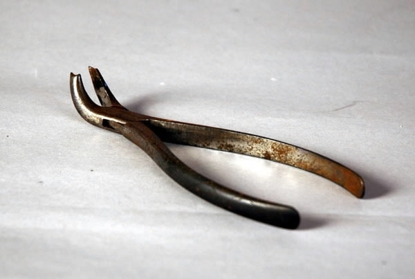 Fodral med tandläkarverktyg, tänger mm. Fodralet av svart läder med foder av röd plysch. Verktygen av stål.