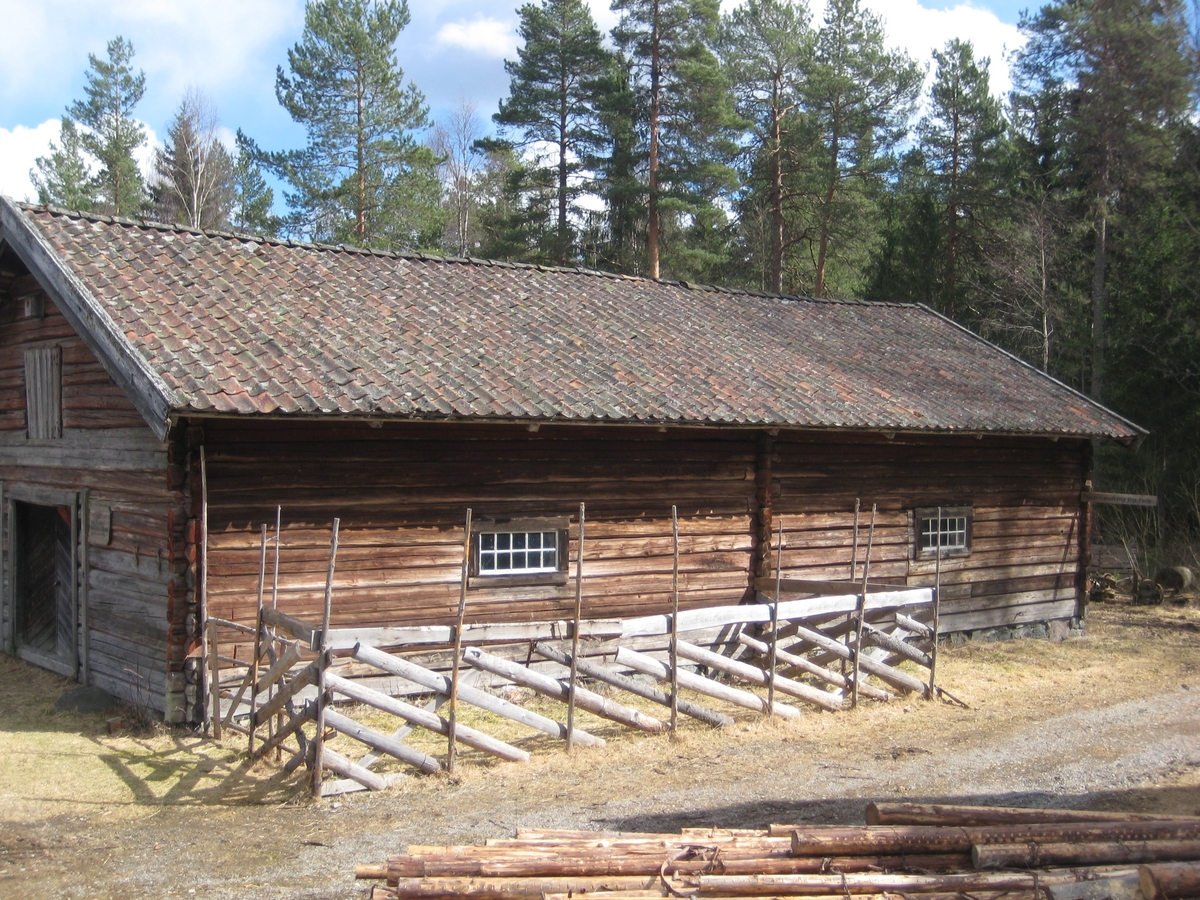 Lasfet fjøs i en stasje. Inngang gjennom doble dører fra begge gavlender. Fjøset er delt i to like store deler med en laftet vegg på tvers midt på.