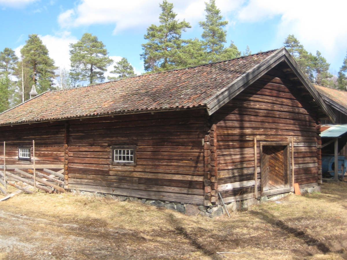 Lasfet fjøs i en stasje. Inngang gjennom doble dører fra begge gavlender. Fjøset er delt i to like store deler med en laftet vegg på tvers midt på.