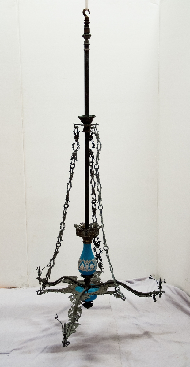 Trearmad takarmatur i metall, med ljusblått porslin.
Påhängd bricka med nr 17, etikett med text: "taklampa 3 armad delvis av blått porslin snittbrännare 1860-tal". Tre kupor saknas, blått glas inne i armaturen.