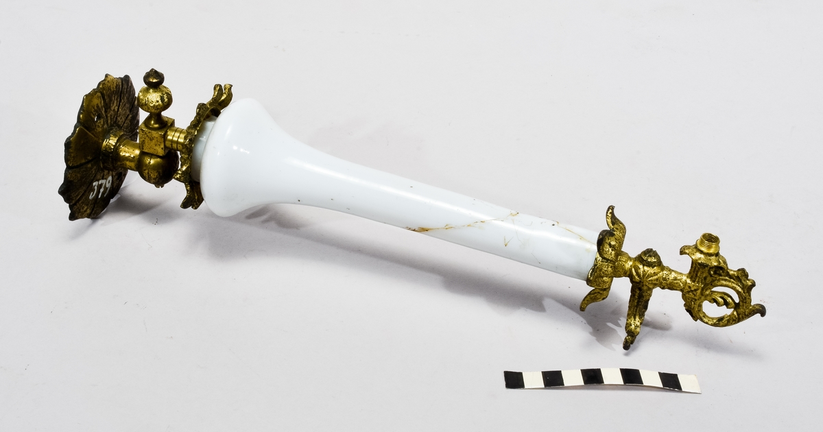 Väggarmatur i mässing och vitt porslin, porslinet spräckt och ihoplimmat.
Påmålad märkning "379".