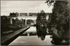 Persontåg på järnvägsbron ovanför akvedukten i Håverud.