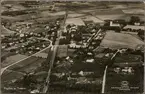 Flygfoto på stad med bangård, station och jordbruk i bild.