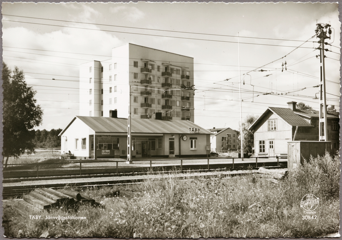 Stationsområde och elektrifierad bangård med höghus i bakgrunden.